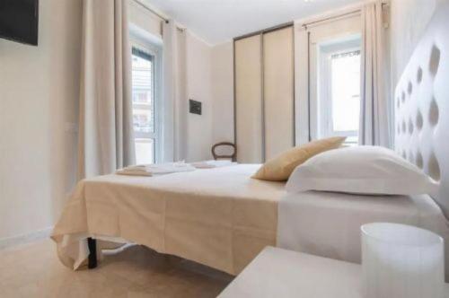 a white bedroom with a bed and a window at Let's go to Rome in Rome