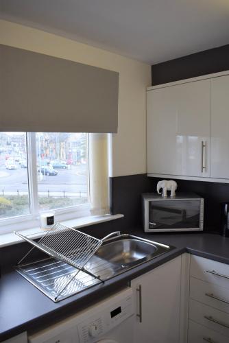 フォルカークにあるKelpies Serviced Apartments Alexander- 2 Bedroomsのシンクと電子レンジ付きのキッチン
