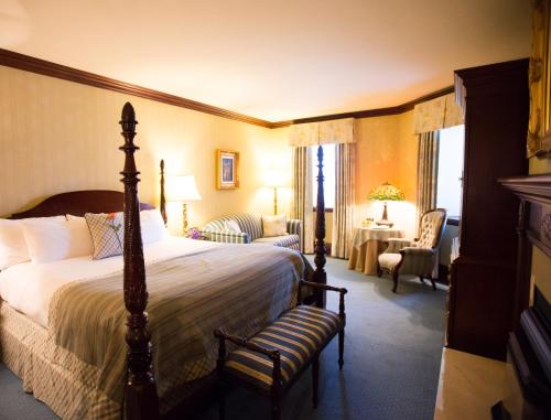 a bedroom with a bed and a chair and a room at Prince of Wales in Niagara on the Lake