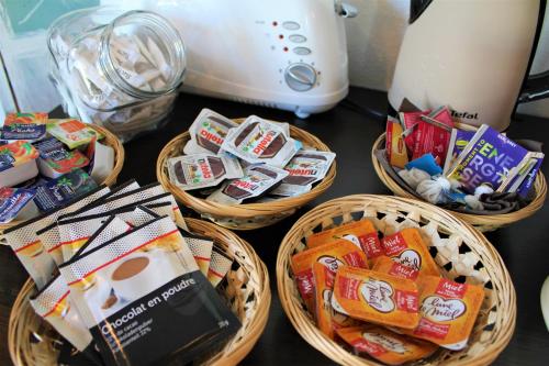 four baskets filled with snacks on a counter at KOSY Appart'Hôtels - Campus Del Sol Esplanade in Montfavet