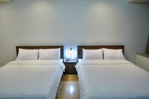 two beds sitting next to each other in a room at Incheon Airport Guesthouse in Incheon