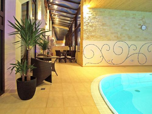 a pool in a room with chairs and a table at Hotel Fajkier in Kroczyce