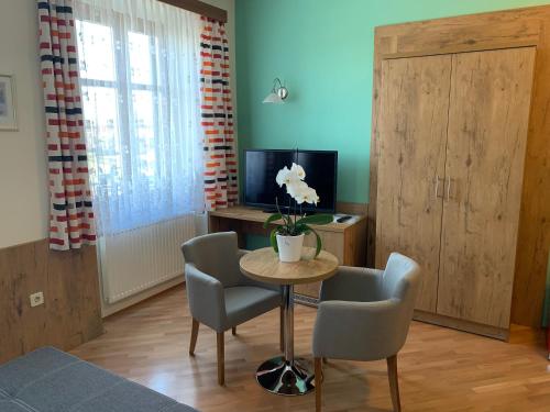 a living room with a table and chairs and a television at Gasthof Wagner Restaurant-Pension in Halbenrain