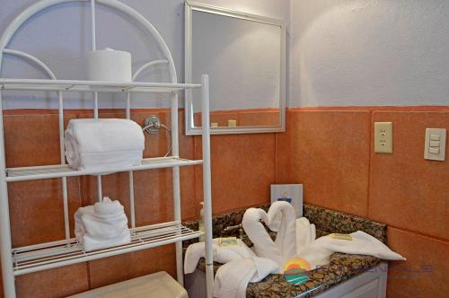 y baño con lavabo, toallas y espejo. en Abel's Villa by FMI Rentals, en Puerto Peñasco