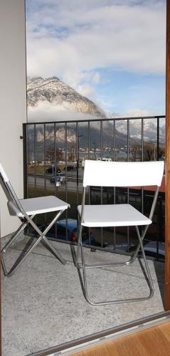 a chair and a table on a balcony with a view at COZY LAKE COMO APARTMENTS in Valmadrera