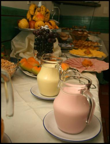 a table with two glasses of milk and a buffet of food at Posada del Frayle Bentos in Fray Bentos