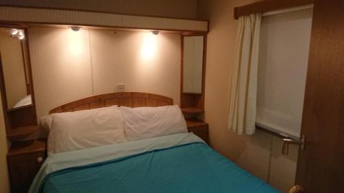 ein Schlafzimmer mit einem Bett mit einem Kopfteil aus Holz in der Unterkunft Mobile Home in Frejus, South of France in Fréjus