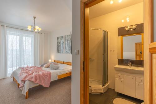 1 dormitorio con cama, ducha y lavamanos en Willa Gawra II - 100 m do wyciągów narciarskich , 900 m do term, en Bukowina Tatrzańska