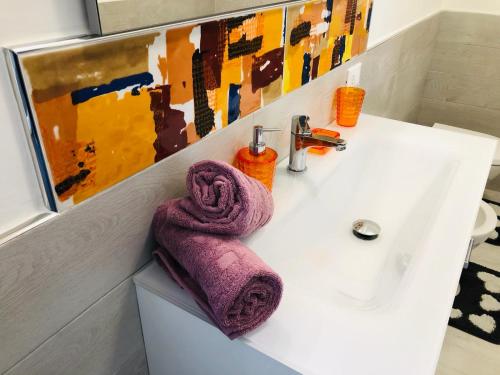 a bathroom sink with a purple towel on it at La Terrazza della Nonna in Palermo