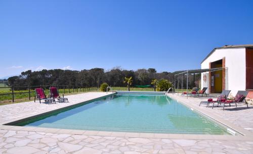 a swimming pool with chairs and a house at B&B El Ranxo in Franciach