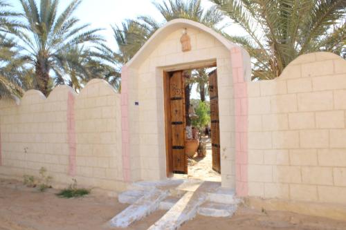 a small brick building with a wooden door at Maison Proche De Désert Douz in Douz