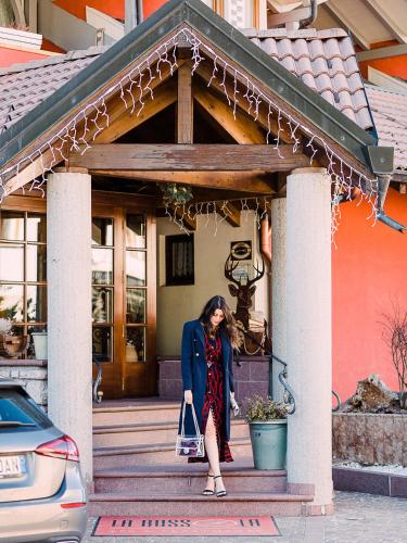 a woman standing on the steps of a house at Hotel La Bussola in Andalo