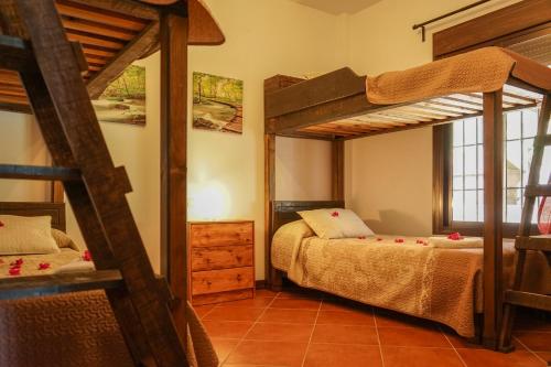 a bedroom with two bunk beds and a window at Alojamiento Rural Caminito del Rey in El Chorro