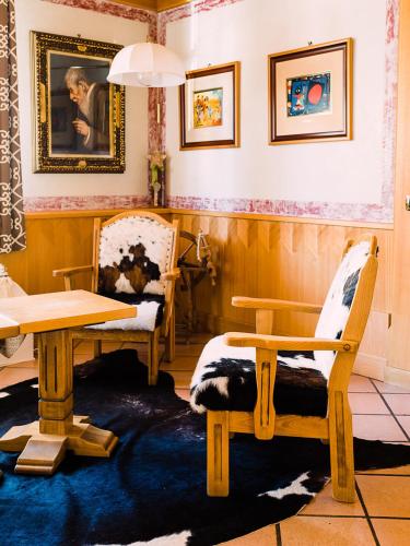 a room with two chairs and a table and a table and chairs at Hotel La Bussola in Andalo