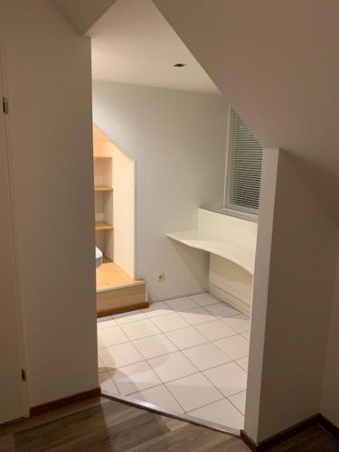 an empty room with a staircase and a white floor at Vakantie huisjes Duinrand Drunen in Drunen