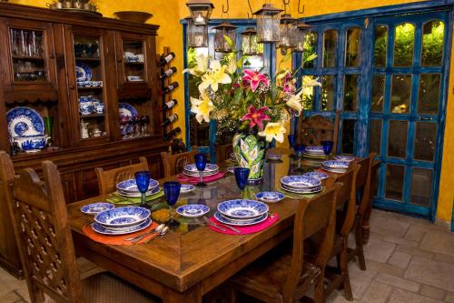 a dining room table with blue and white dishes and flowers at Hacienda Boutique B&B and Spa Solo Adultos in Cozumel