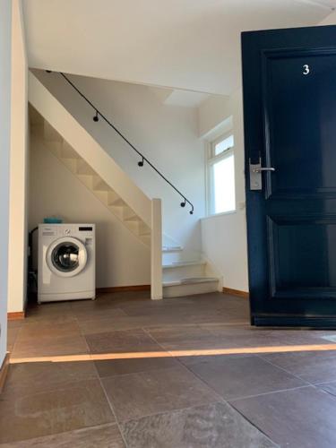 a room with a washing machine and a staircase at Vakantie huisjes Duinrand Drunen in Drunen