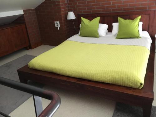 a bedroom with a bed with green pillows at Spa102 in Pobierowo