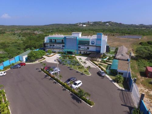 a large building with cars parked in a parking lot at Hotel Campestre El Cisne in Barranquilla