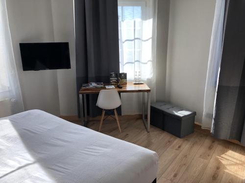 ein Schlafzimmer mit einem Bett und einem Schreibtisch mit einem Stuhl in der Unterkunft Hotel Restaurant zum Löwen in Duisburg