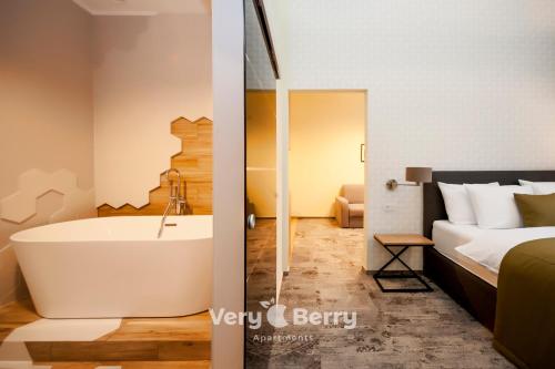 a white bath tub sitting next to a white toilet at Very Berry - Podgorna 1c - Old City Apartments, check in 24h in Poznań