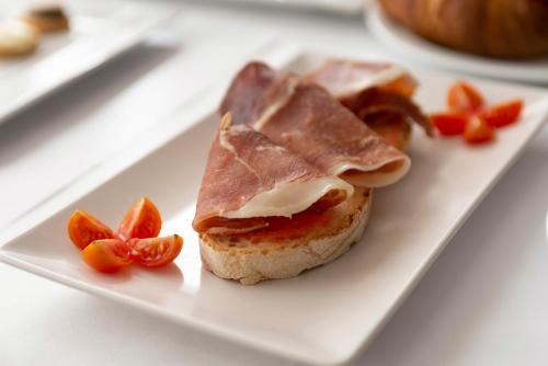 a white plate with a sandwich with peanut butter and fruit at Hotel & Spa Real Jaca in Jaca