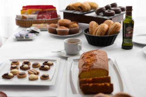 a table with plates of pastries and bread and a bottle of wine at Hotel & Spa Real Jaca in Jaca