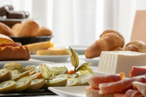 a table topped with plates of food with bread at Hotel & Spa Real Jaca in Jaca