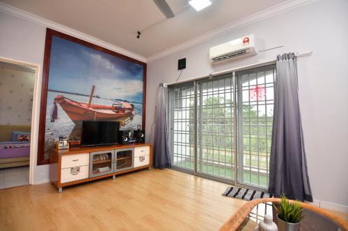 un soggiorno con una grande TV e una grande finestra di Gone Fishin' @ Kuala Selangor ( 2 min to Sky Mirror Jetty) a Kuala Selangor