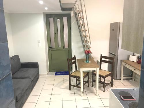 a living room with a table and chairs and a couch at Odyssey Apartment in Palaiochóra