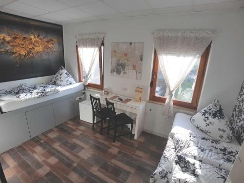 a bedroom with a desk and a bed and a table at BoardingHouse Sinsheim zentral am Burgplatz in Sinsheim