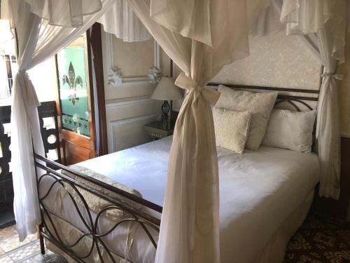 a bedroom with a white bed with a canopy at Hotel Elena in Puebla