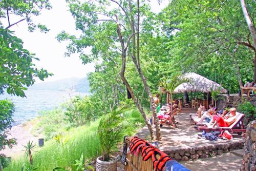 a group of people sitting on chairs by the water at San Simian Lodge in La Laguna