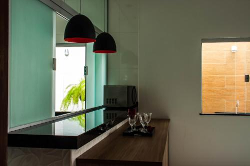 a kitchen with two lamps and a counter with glasses at Pousada São Francisco in São João Batista do Glória