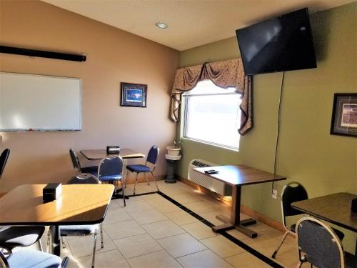 a classroom with tables and chairs and a white board at Abby Inn in Abbotsford