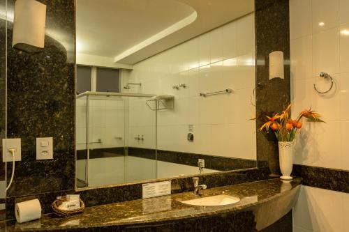 a bathroom with a sink and a glass shower at Lindóya Hotel in Catalão