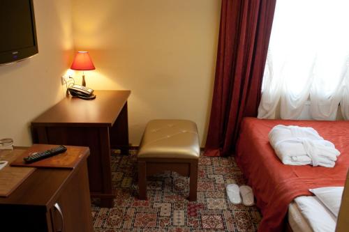 a hotel room with a bedroom with a desk and a bed at Pidkova in Rivne
