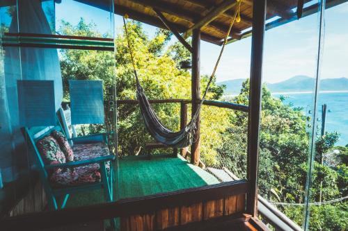 a room with a hammock and a view of the ocean at Hostel do Morro in Florianópolis