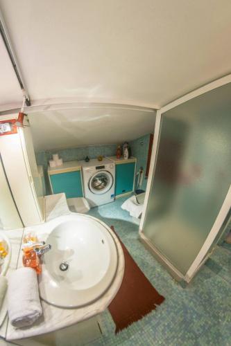 a bathroom with a sink and a washing machine at Marconi Rooms and Apartments in Verona
