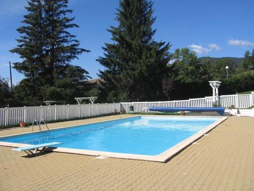 Enveitg的住宿－Estudio con piscina en Enveitg，一个带白色围栏的庭院内的游泳池