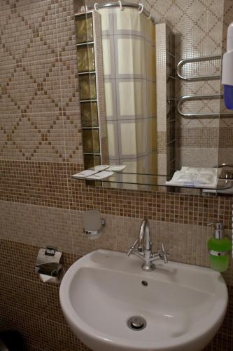 a bathroom with a sink and a mirror at Pidkova in Rivne