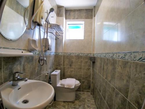 a bathroom with a sink and a toilet and a mirror at Hotel Jelai @ Mentakab in Mentekab