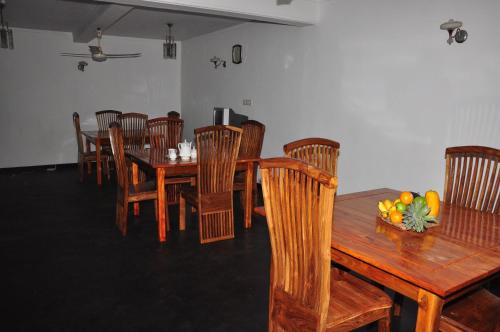 a dining room with a wooden table and chairs at Villa Senowin in Anuradhapura