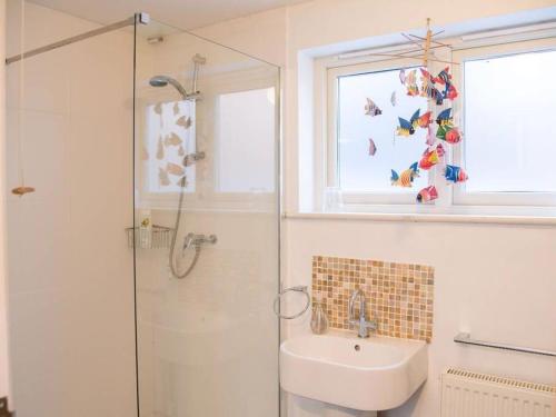 a bathroom with a shower and a sink and a window at Suilven Holiday Let in Aldeburgh