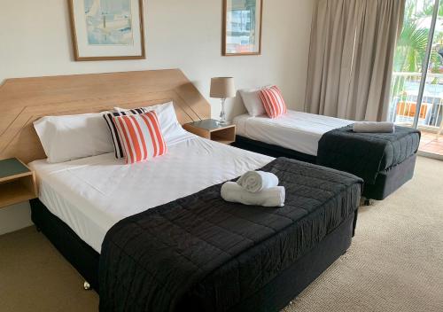 a hotel room with two beds and a ottoman at Outrigger Burleigh in Gold Coast