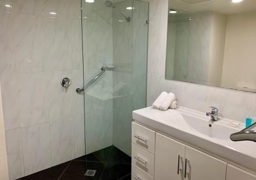 a bathroom with a shower, sink, and tub at Outrigger Burleigh in Gold Coast