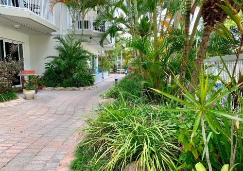 a courtyard with palm trees and a brick walkway at Outrigger Burleigh in Gold Coast