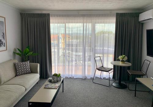 a living room with a couch and a table at Outrigger Burleigh in Gold Coast