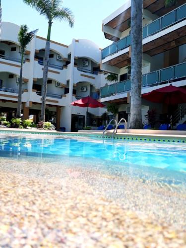 a swimming pool in front of a hotel at MarySol Las Palmas in Rincon de Guayabitos