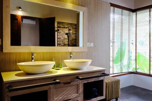a bathroom with two sinks and a mirror at Artoria Dream Villas Bali in Nusa Dua